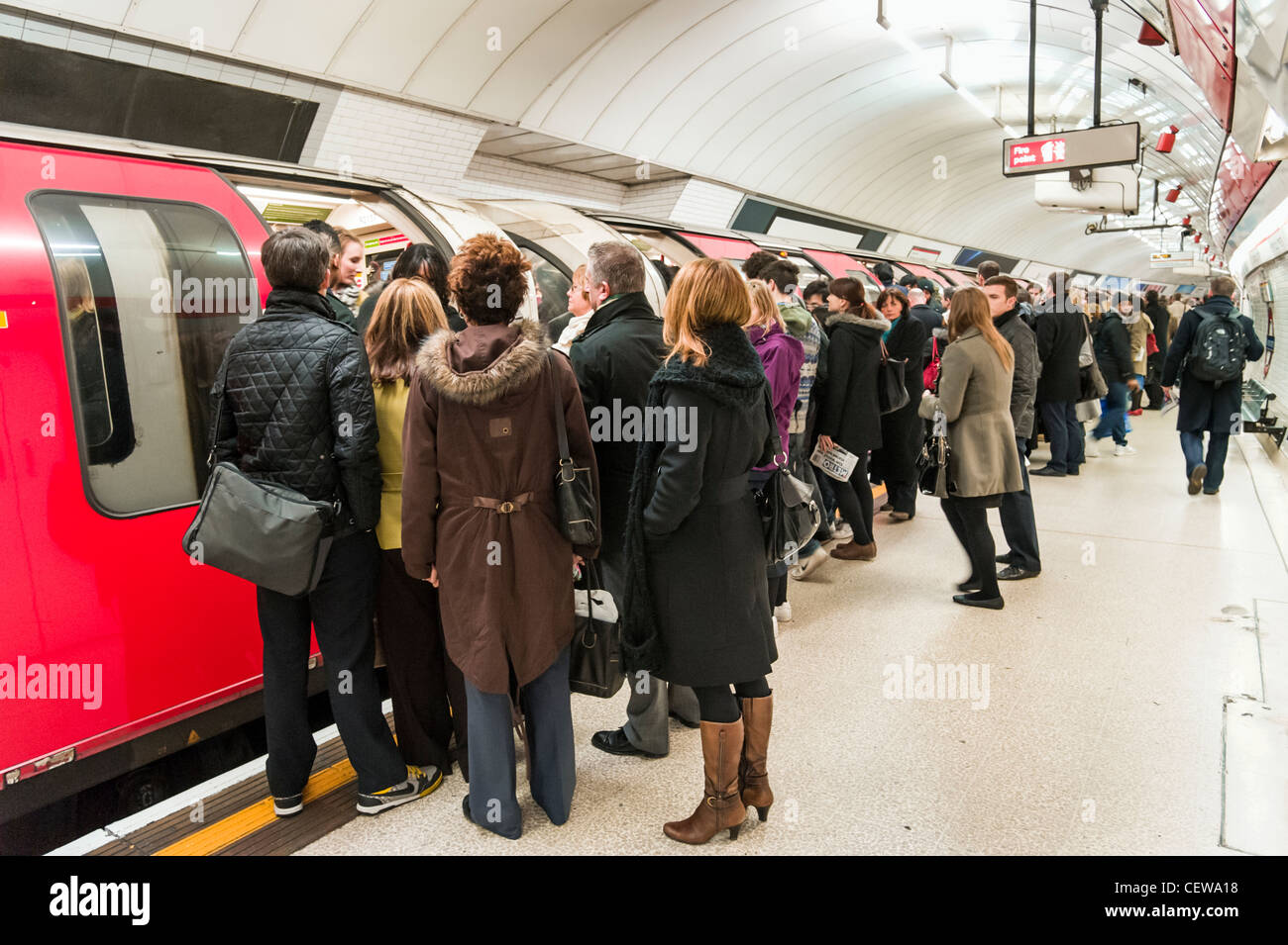 Pendolari cercando di bordo sovraffollato Central Line della metropolitana di Londra trasporto durante la mattinata Rush Hour, REGNO UNITO Foto Stock
