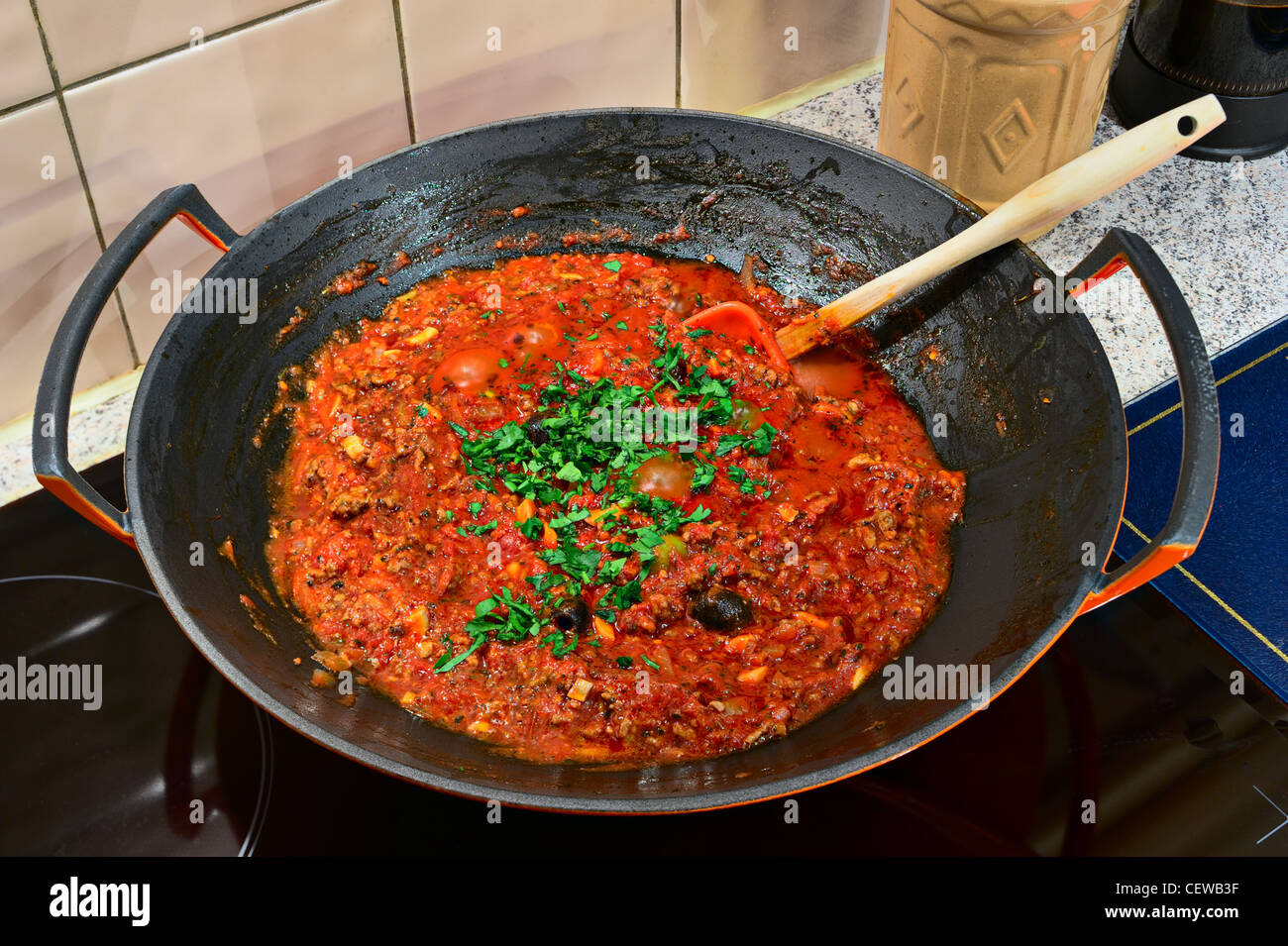 Il ragù alla bolognese la cottura in un wok su un fornello ad induzione Foto Stock