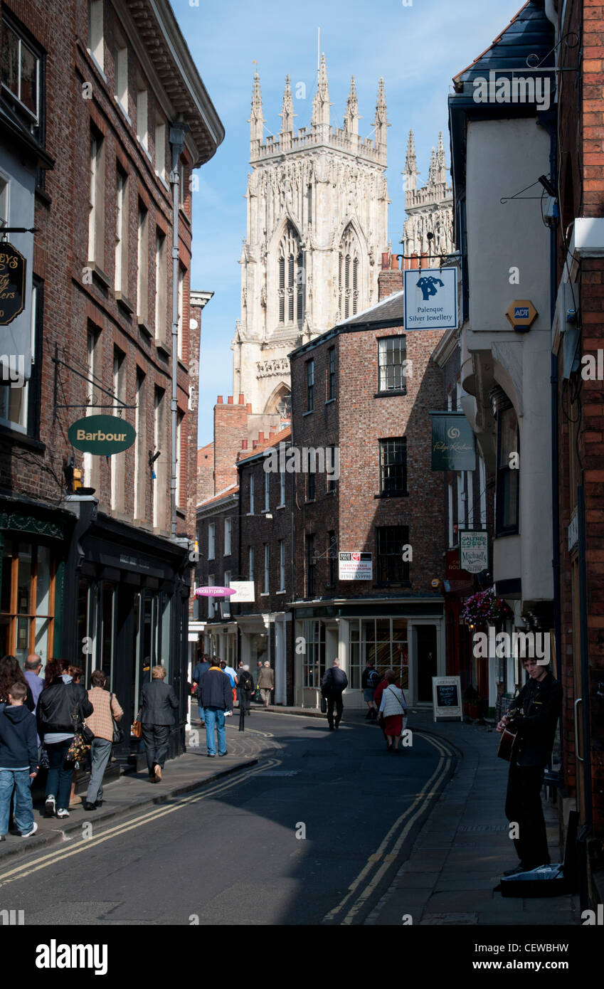 Busker in bassa Petergate con York Minster in background, centro di York. Foto Stock