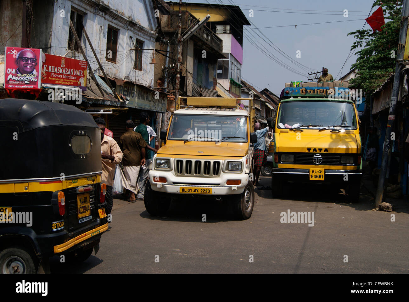 I veicoli che attraversano attraverso il lettore RUSH strette strade del Kerala, India Foto Stock