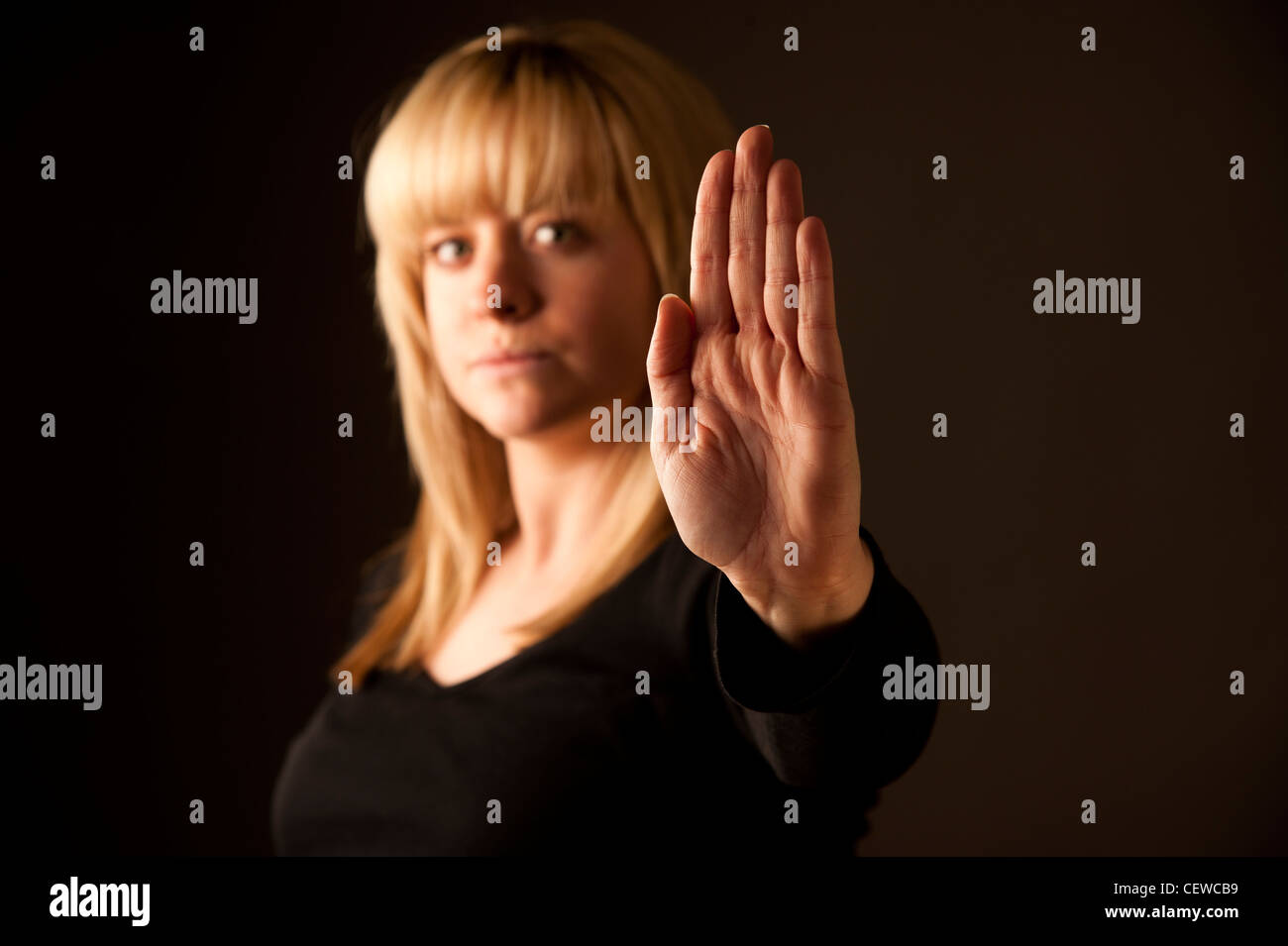 Una bionda ragazza dai capelli donna con la sua mano stesa a significare STOP / NO : Nessun mezzo n. Foto Stock