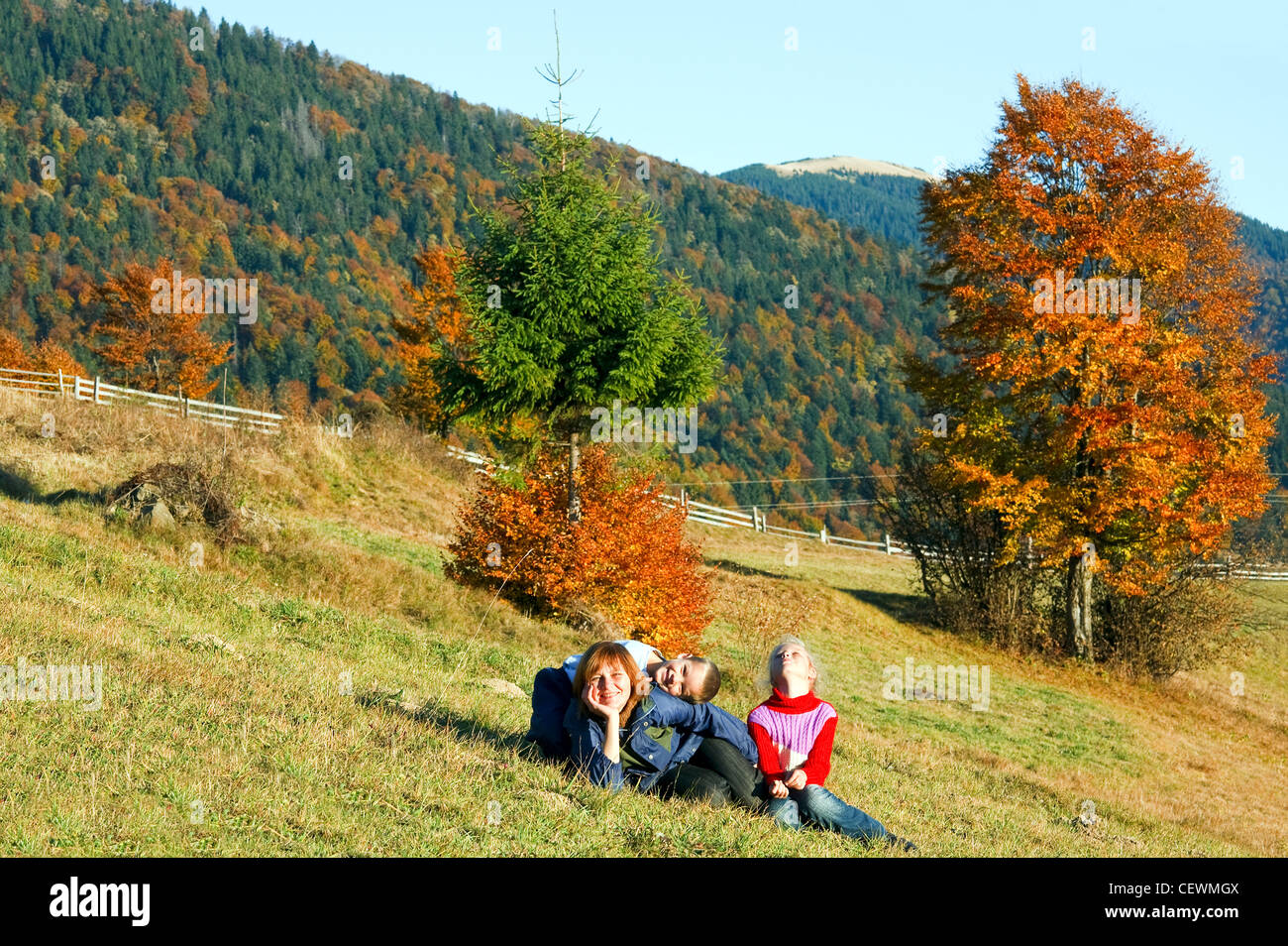 Sunny autunno di foreste di montagna e la famiglia di fronte (sul versante della montagna) Foto Stock