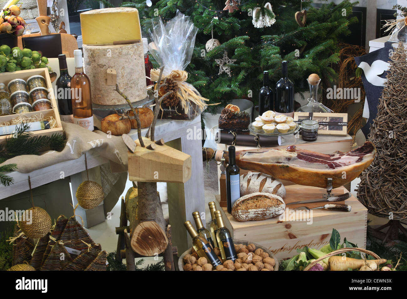 Un Natale la visualizzazione di vari prodotti alimentari e vino, rustico decorazioni di Natale compresa una renna in legno e un albero di natale Foto Stock
