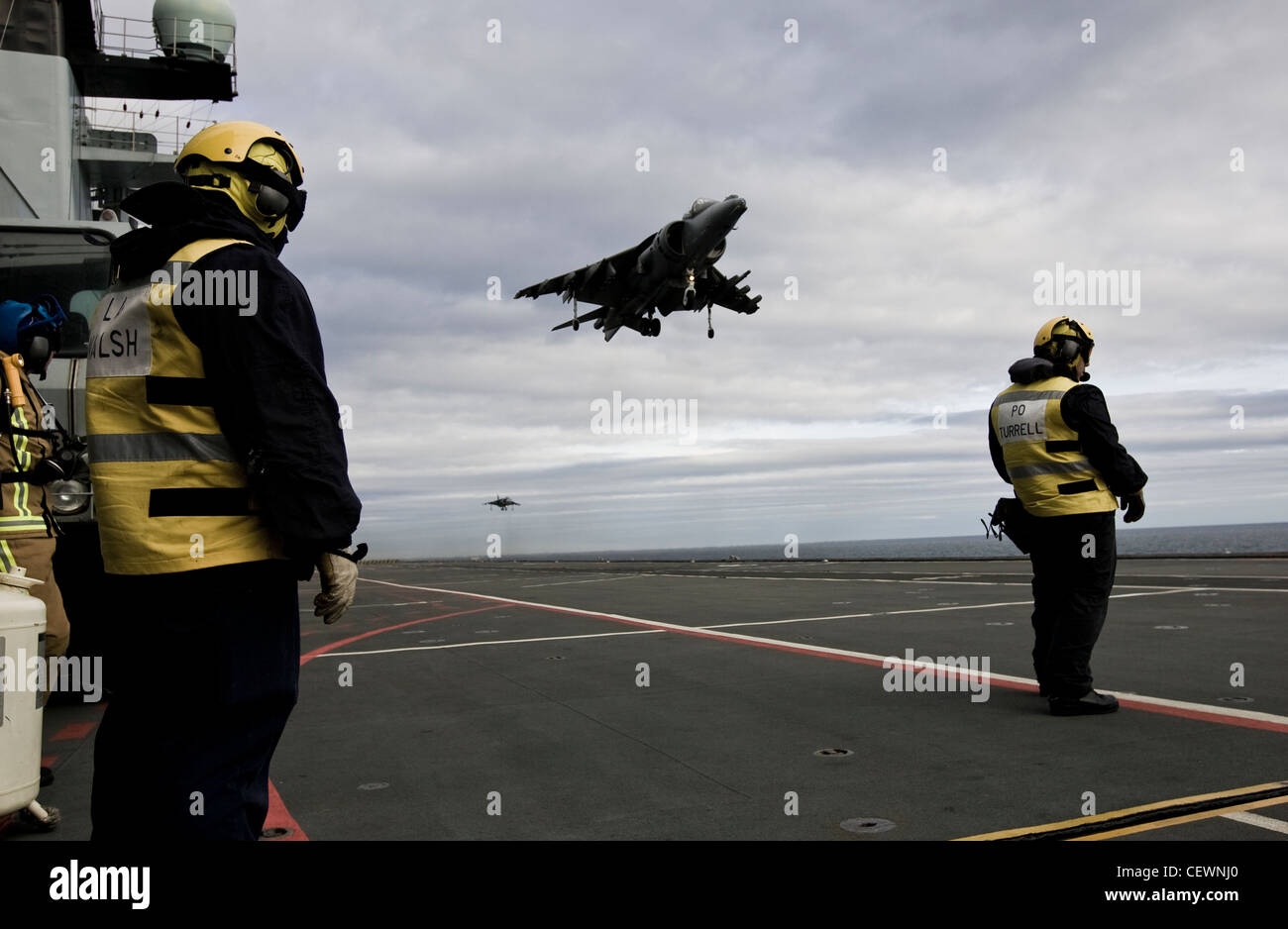 Harrier jet e equipaggio navale sulla portaerei HMS Illustrius Foto Stock