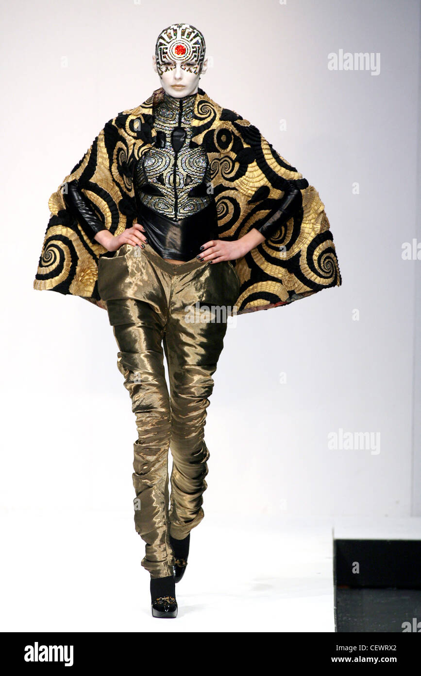 Manish Arora Londra pronto a indossare in autunno e inverno modello testa calva dipinte di bianco e oro punto rosso al centro della fronte indossando Foto Stock