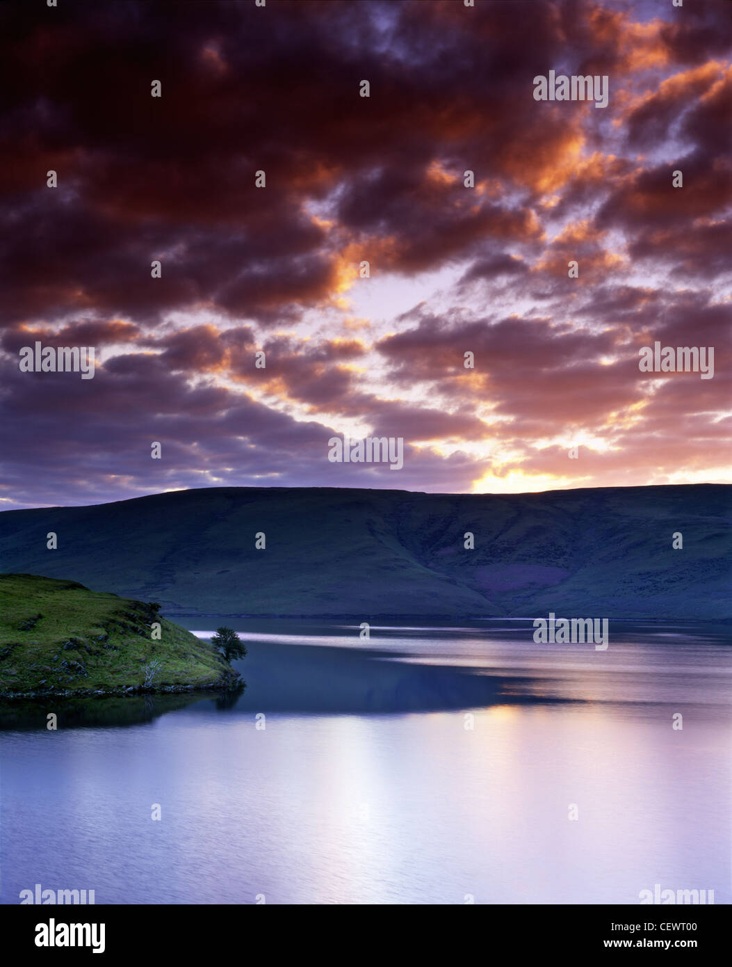 Nuvole pesanti parte come Aurora rompe su Penygarreg serbatoio nell'Elan Valley. Foto Stock