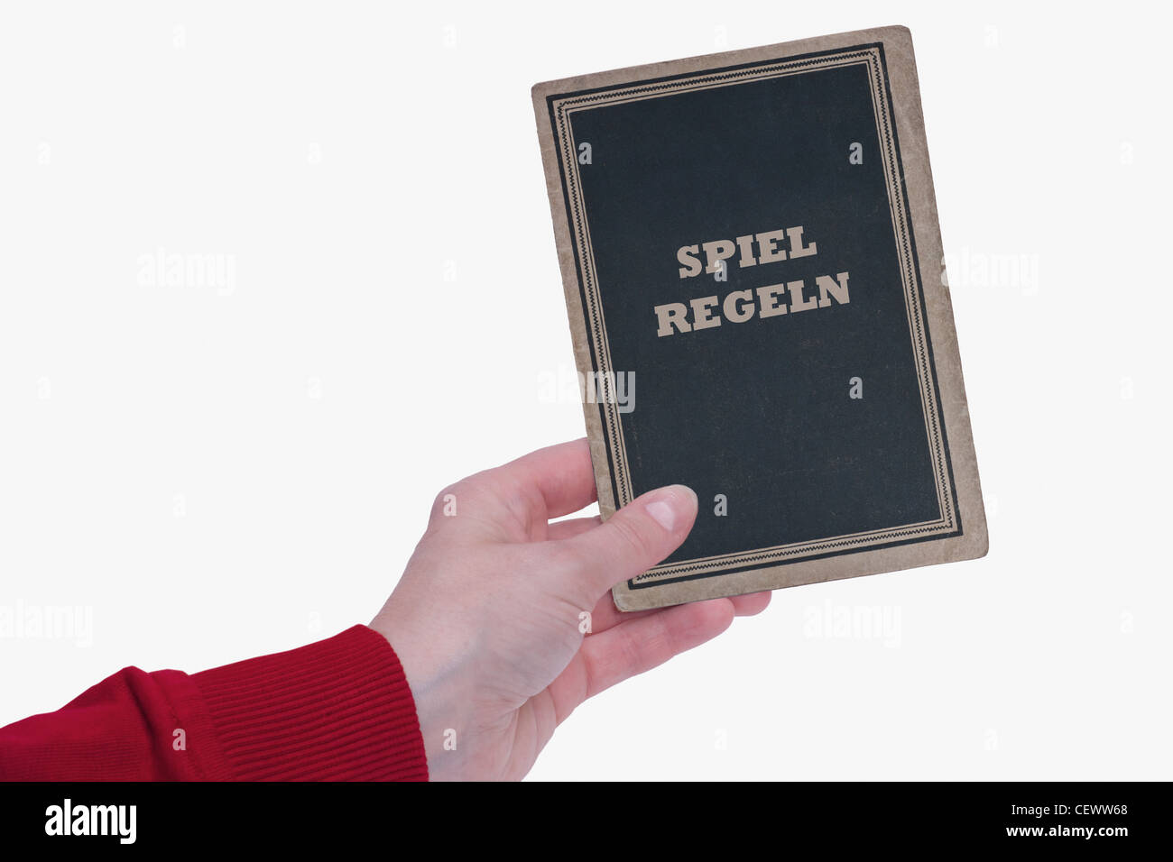 Ein Buch mit der Aufschrift 'Spielregeln' wird in der gehalten mano | un libro con il titolo tedesco di 'Spielregeln' è tenuto in mano Foto Stock