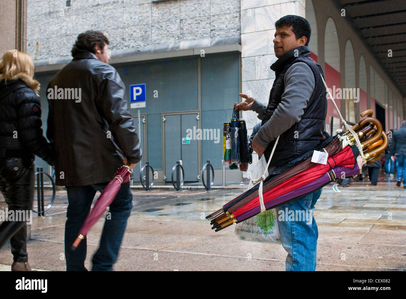 Immigrati bengalesi che vende ombrelli, Milano, Italia Foto Stock
