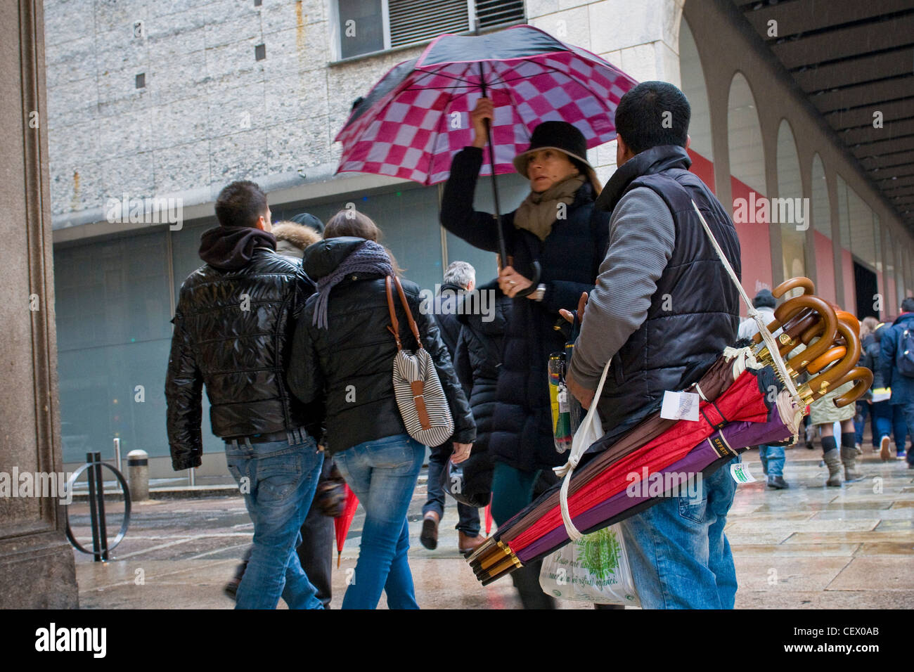 Immigrati bengalesi che vende ombrelli, Milano, Italia Foto Stock