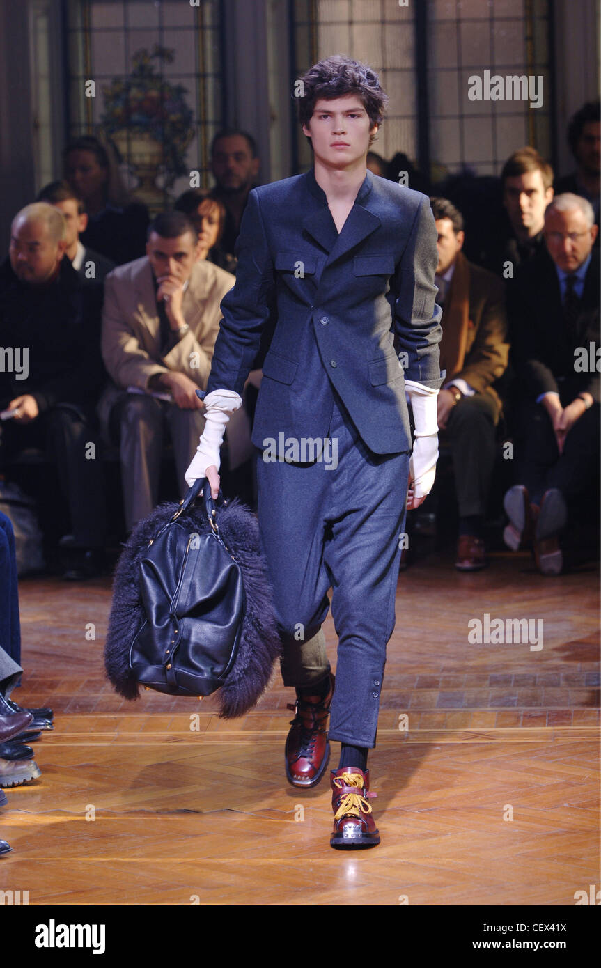 Miu Miu Menswear Milano A W Brunette maschio che indossa un abito grigio  ritagliato pantaloni lunghi senza dita bianco guanti, scarpe marrone giallo  Foto stock - Alamy