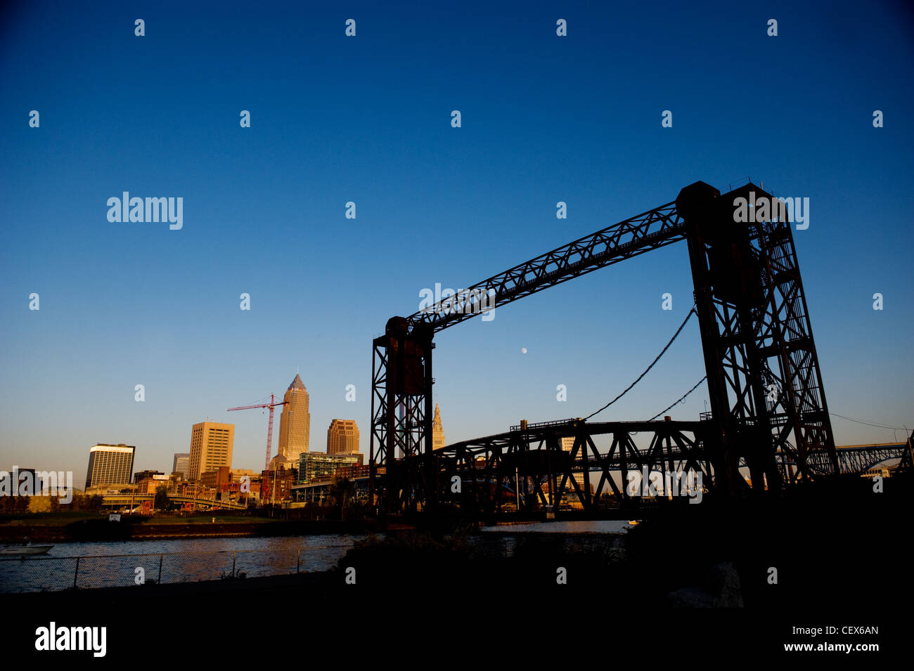 Un ponte di sollevamento attraverso il Fiume Cuyahoga con la Cleveland, Ohio skyline in background su un cielo blu chiaro giorno con la luna Foto Stock