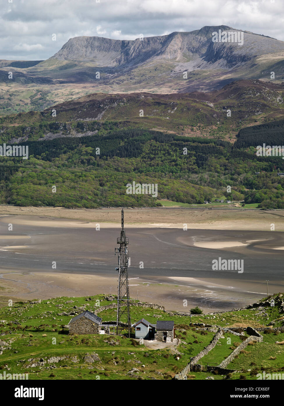 Un montante di telecomunicazioni in alto sulla collina che guarda su Mawddach Estuary con una veduta distante di Cadair Idris. Foto Stock