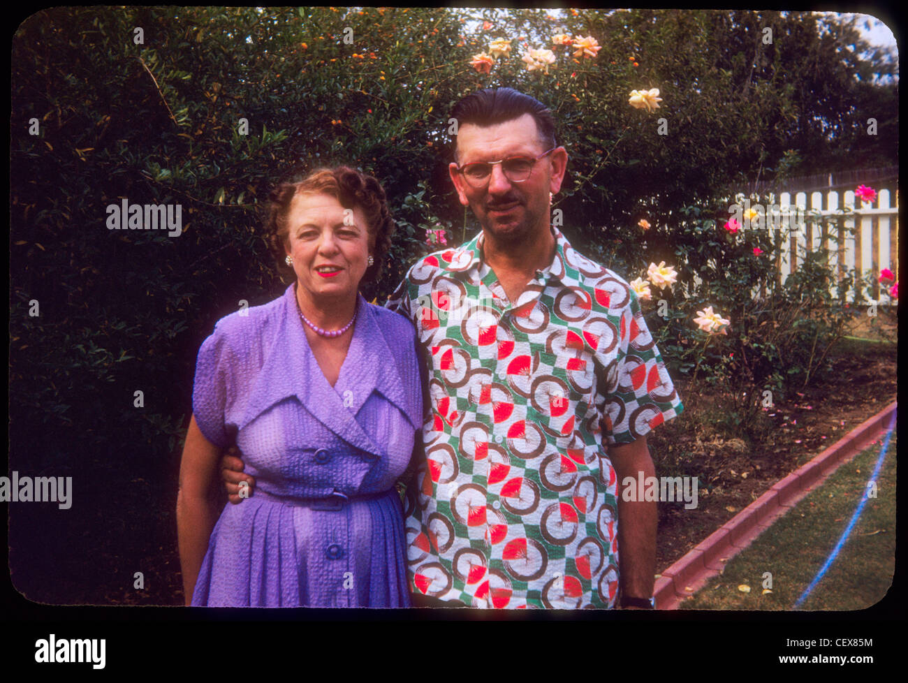 Matura in piedi di fronte a casa in Fullerton Southern California white Picket Fence marito e bianco degli anni cinquanta la moda shirt Foto Stock