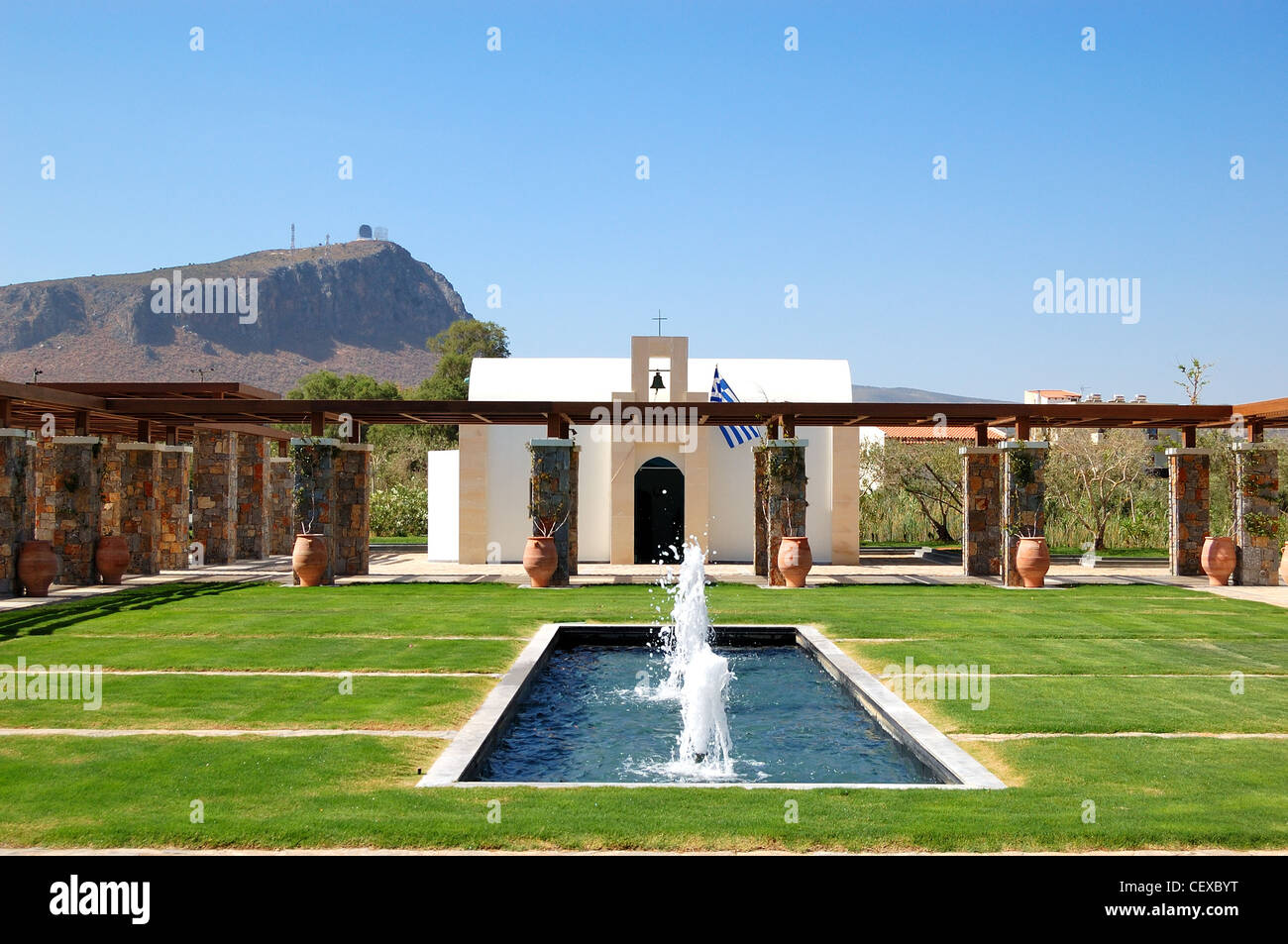 La moderna Chiesa, bandiera greca e fontana, Creta, Grecia Foto Stock