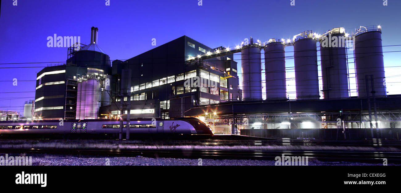 Stabilimento della Lever Unilever Brothers a Bank Quay Warrington, Cheshire al tramonto, con una linea principale Pendolino WCML West Coast Foto Stock