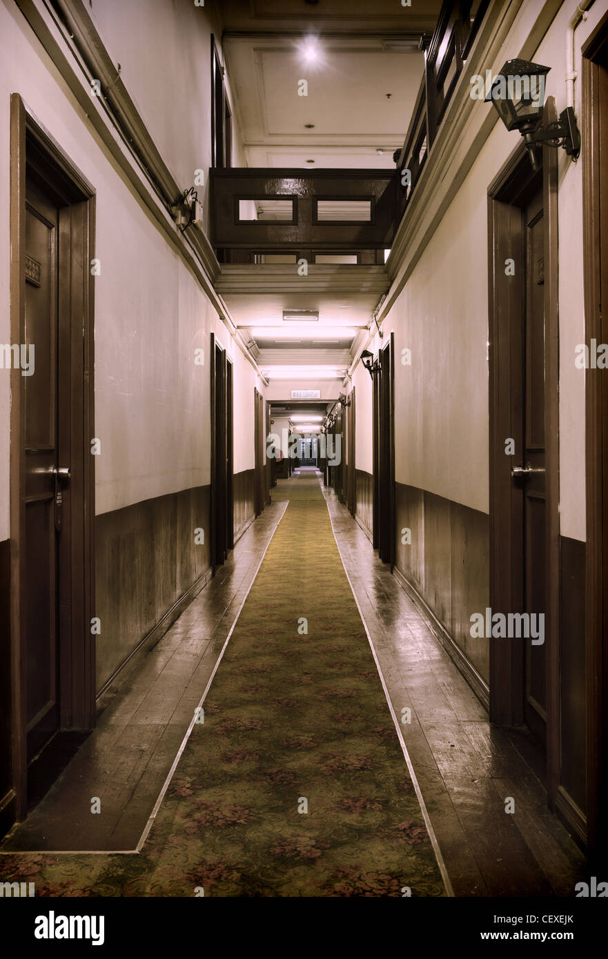 Corridoio con camere all'interno di una ruvida vecchio hotel Foto Stock