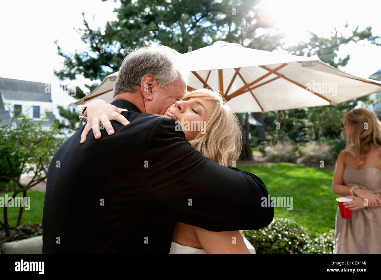 Padre abbracciando la sua figlia il suo giorno di nozze Foto Stock