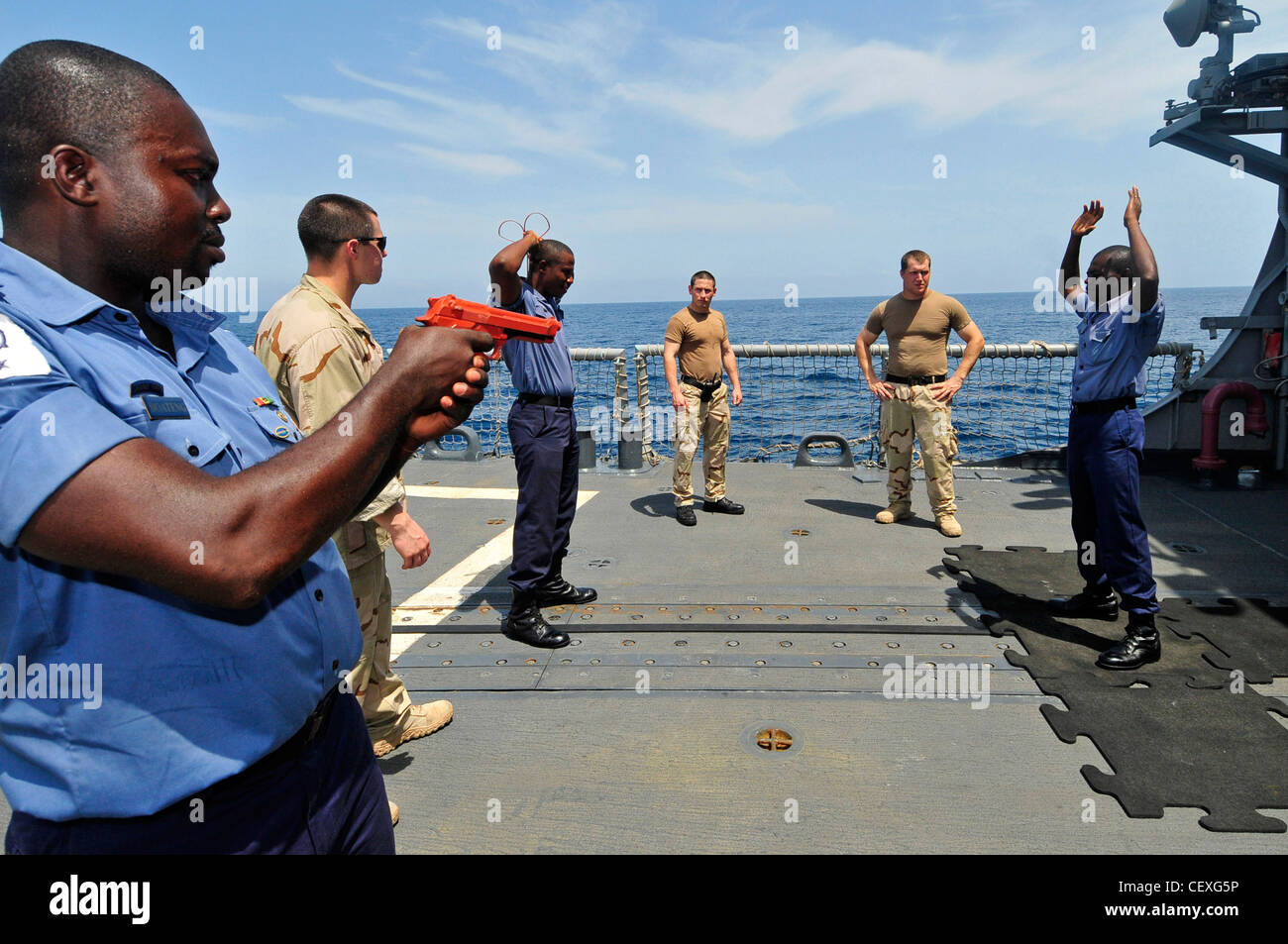 I marinai della fregata missilistica guidata USS Simpson osservano i membri della marina del Ghana mentre praticano operazioni di interdizione marittima come parte della Stazione di partenariato Africa 2012. APS è un'iniziativa internazionale di cooperazione in materia di sicurezza promossa dal Comandante, forze navali statunitensi Europa-Africa, che mira a rafforzare le partnership marittime globali attraverso attività di formazione e collaborazione al fine di migliorare la sicurezza marittima e la sicurezza in Africa. Foto Stock