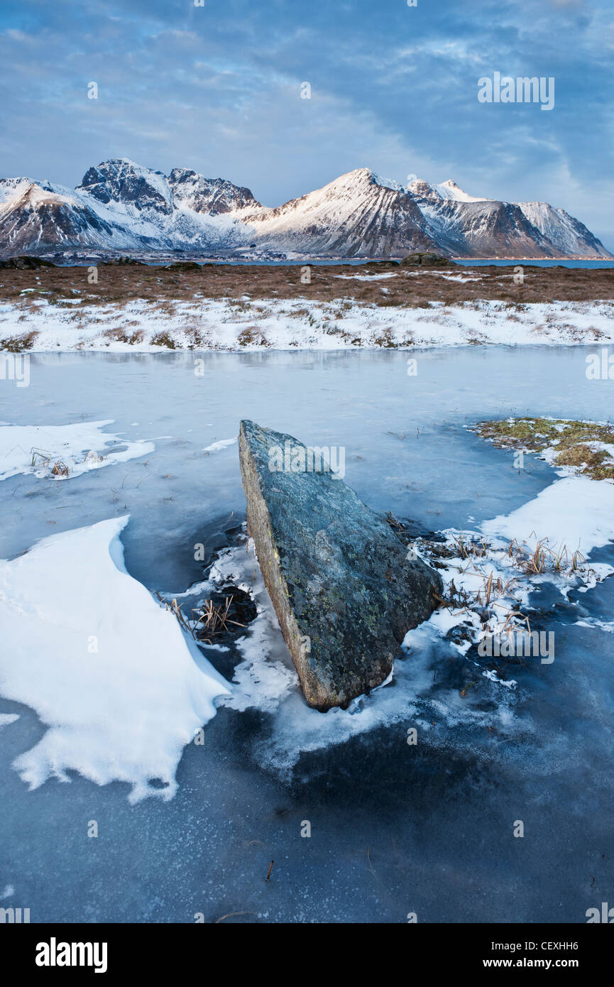 Rock emerge dal laghetto congelato in inverno, Isole Lofoten in Norvegia Foto Stock