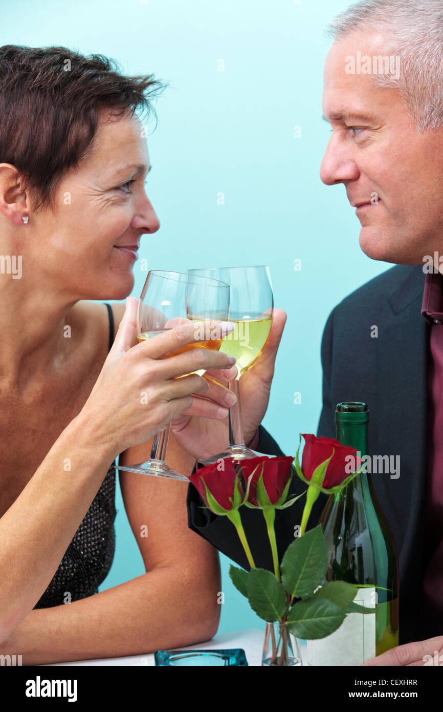 Foto di una coppia sposata giovane azienda di bicchieri di vino e guardando ogni altro mentre seduto in un ristorante. Foto Stock