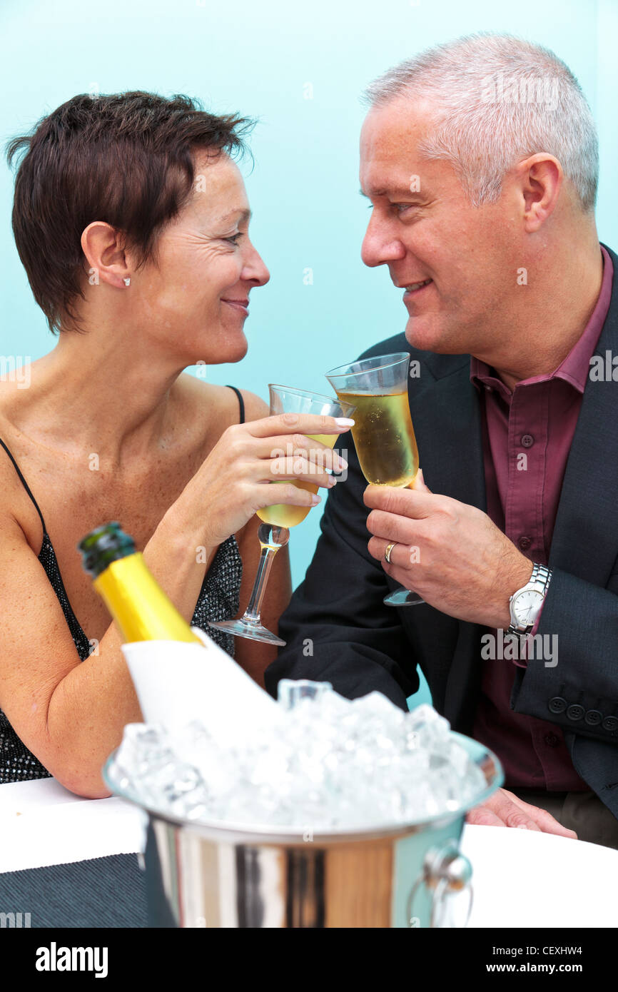 Foto di una matura coppia sposata celebrando con un bicchiere di champagne in un ristorante. Foto Stock