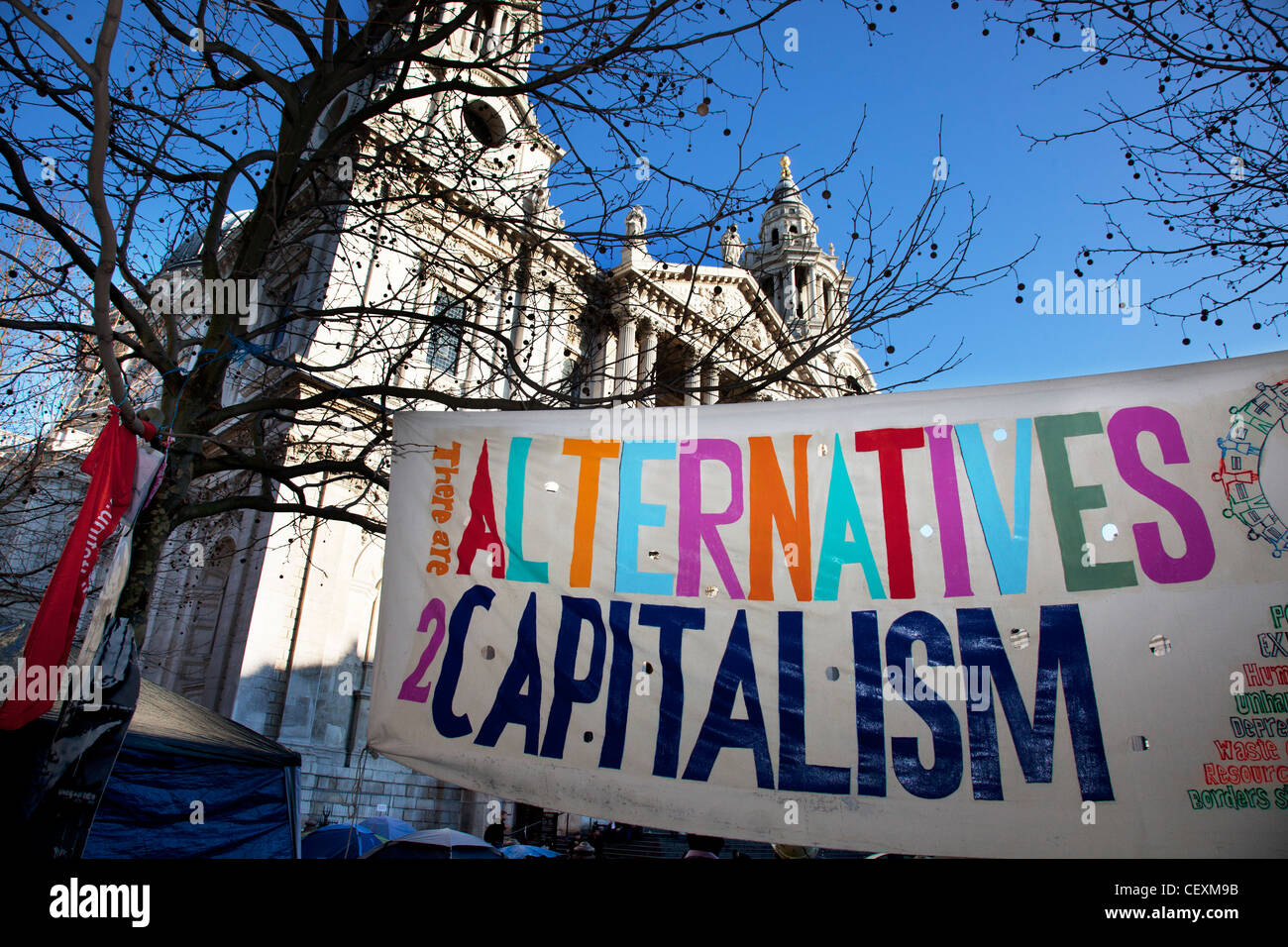 Tende e segni contenenti slogan a occupare Londra LSX sito di protesta a San Paolo, Londra, Regno Unito. Foto Stock