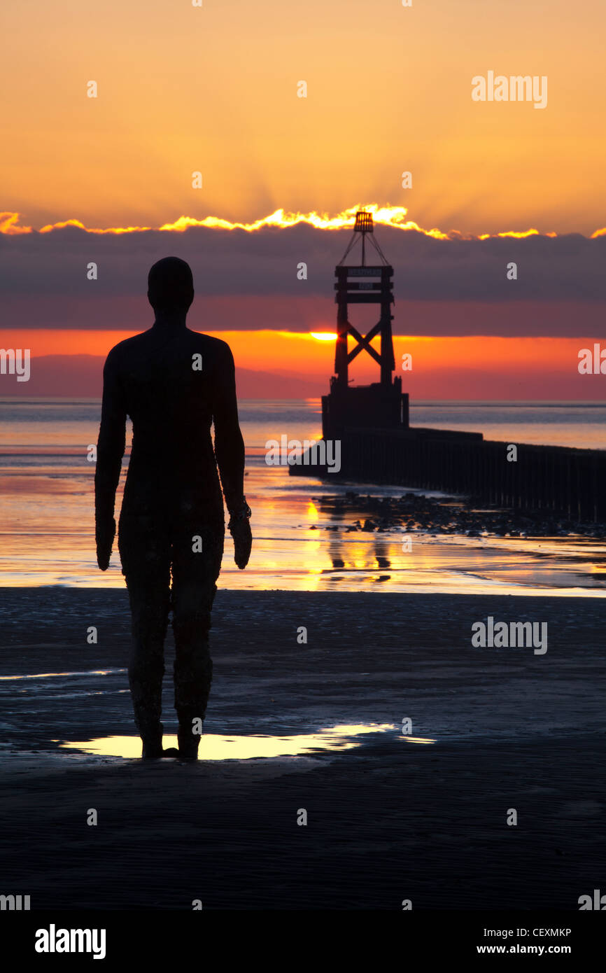 Antony Gormley statua stagliano, tramonto, un altro luogo, Crosby. Foto Stock