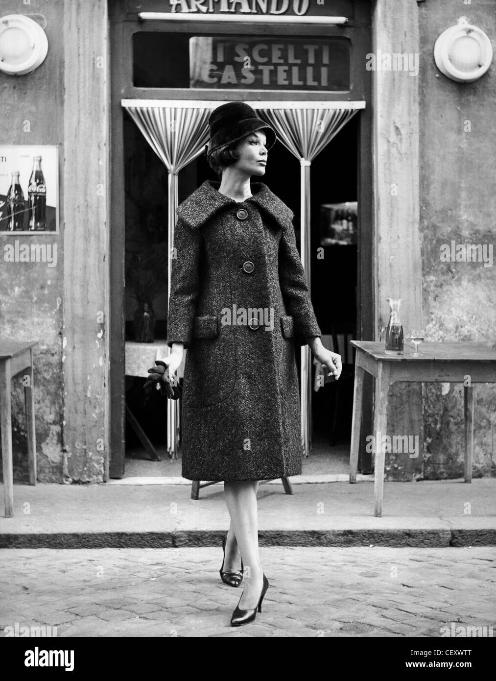 Luciani tweed femmina rivestire con ampi revers, cloche hat e corte calzature; in piedi al di fuori di un negozio a Roma, Italia Elsa Haertter Foto Stock
