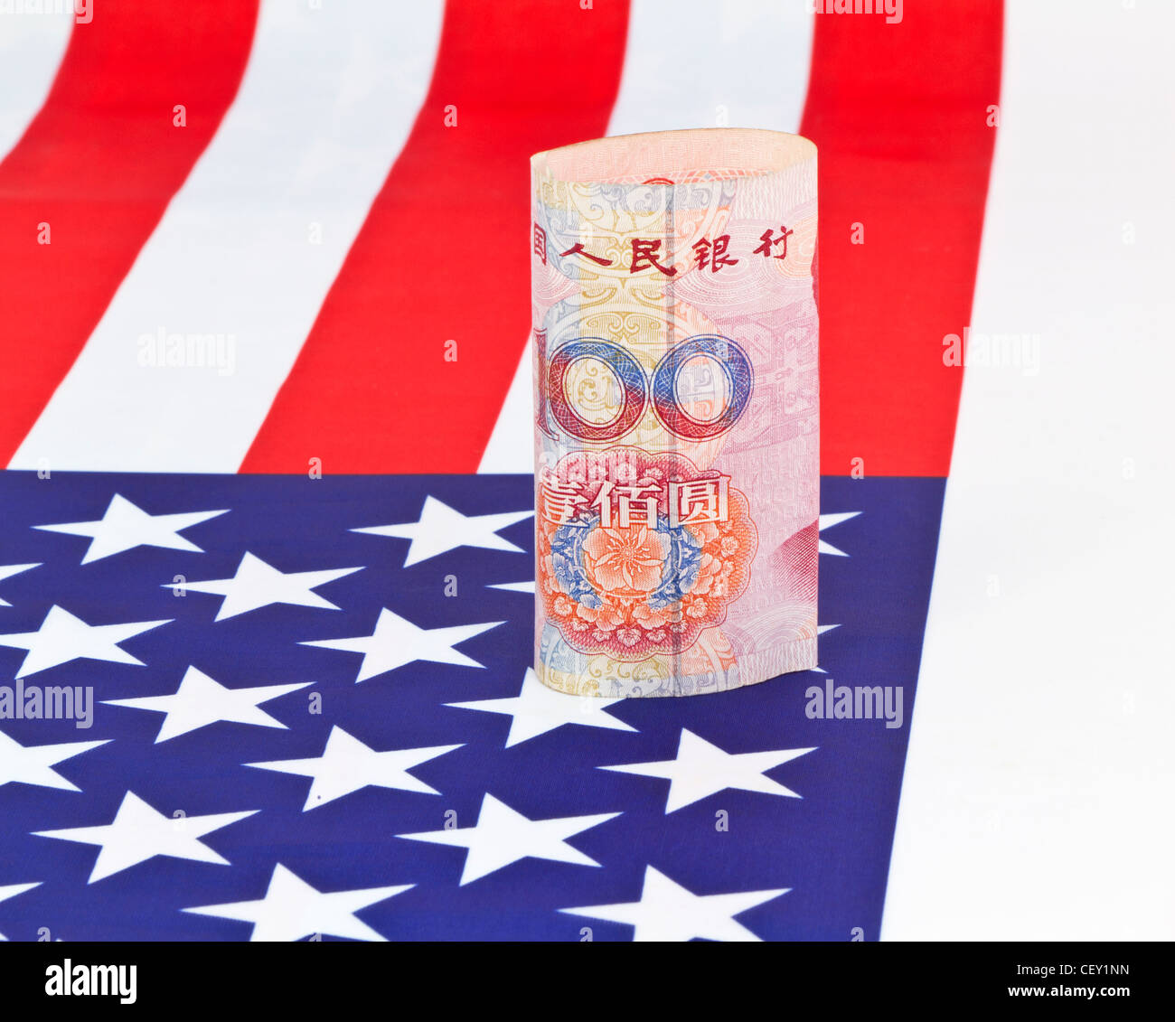 Della Cina di moneta yuan collocato su una bandiera americana riflette il concetto di investimenti asiatici made in America Foto Stock