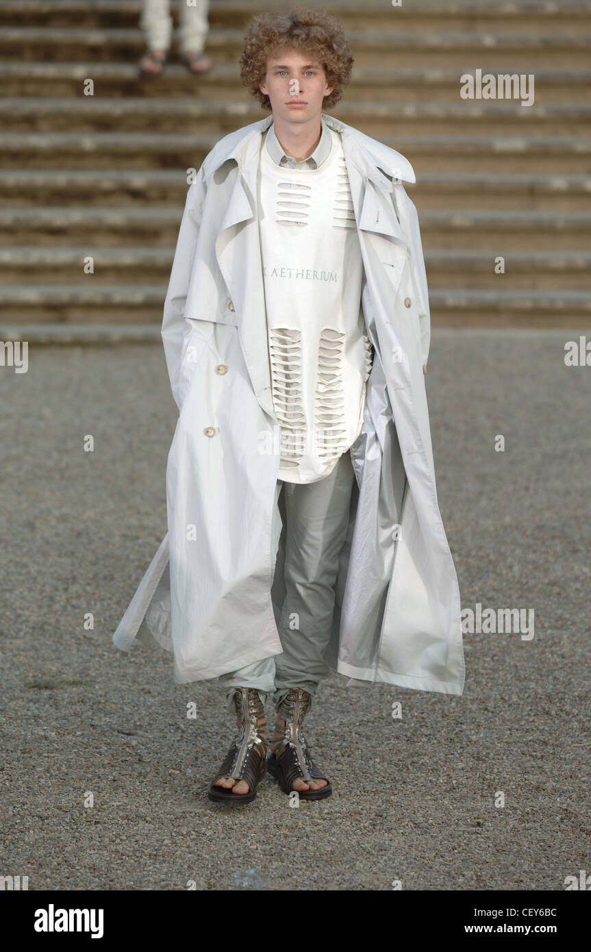 Raf Simons Milano Menswear S S maschio lungo indossa trench coat su bianco  Gilet strappato e combatte grigio nascosto in sandali romano Foto stock -  Alamy