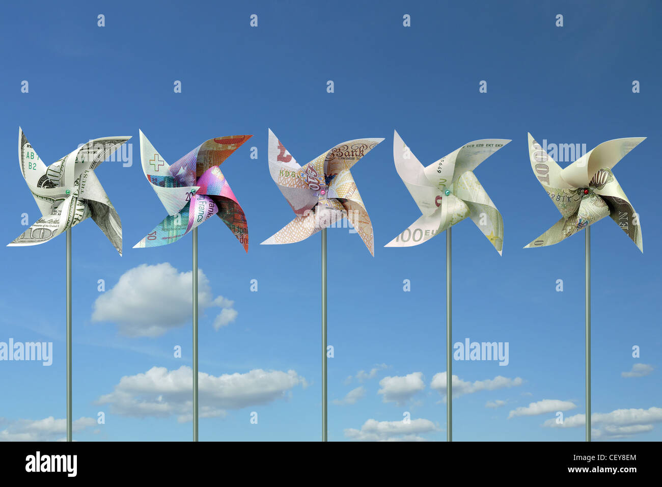 Mulini a vento giocattolo tagliati da cinque grandi mondo banconote in valuta oltre il cielo blu Foto Stock