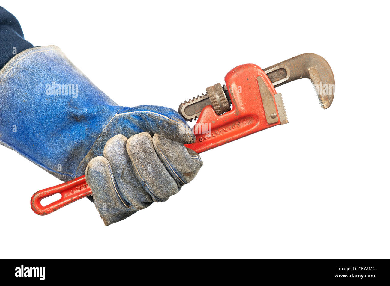 Un uomo con una vecchia, rusty idraulico della chiave a tubo indossando usurati guanti di officina. Foto Stock