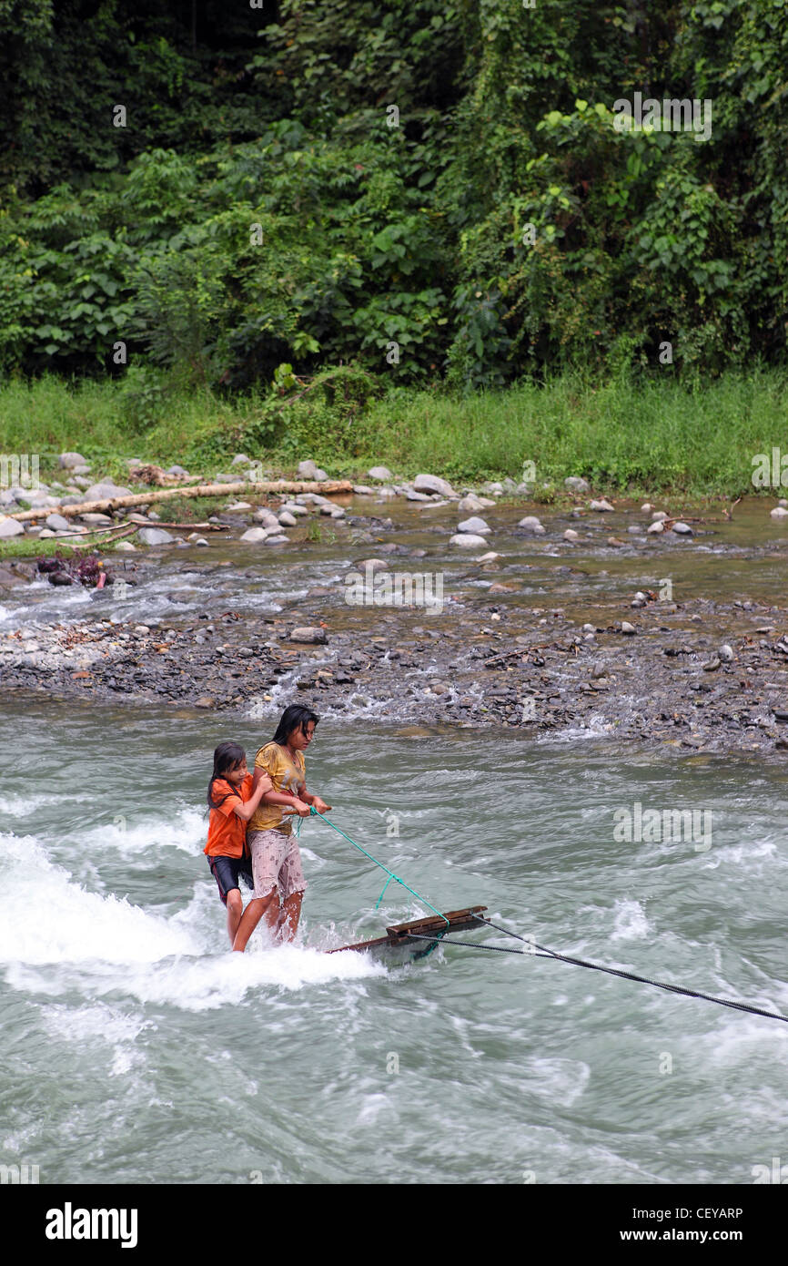 Ragazze divertimento navigando sul fiume Bahorok utilizzando una fune ancorata e porta di legno. Il Bukit Lawang, Gunung Leuser National Park Foto Stock