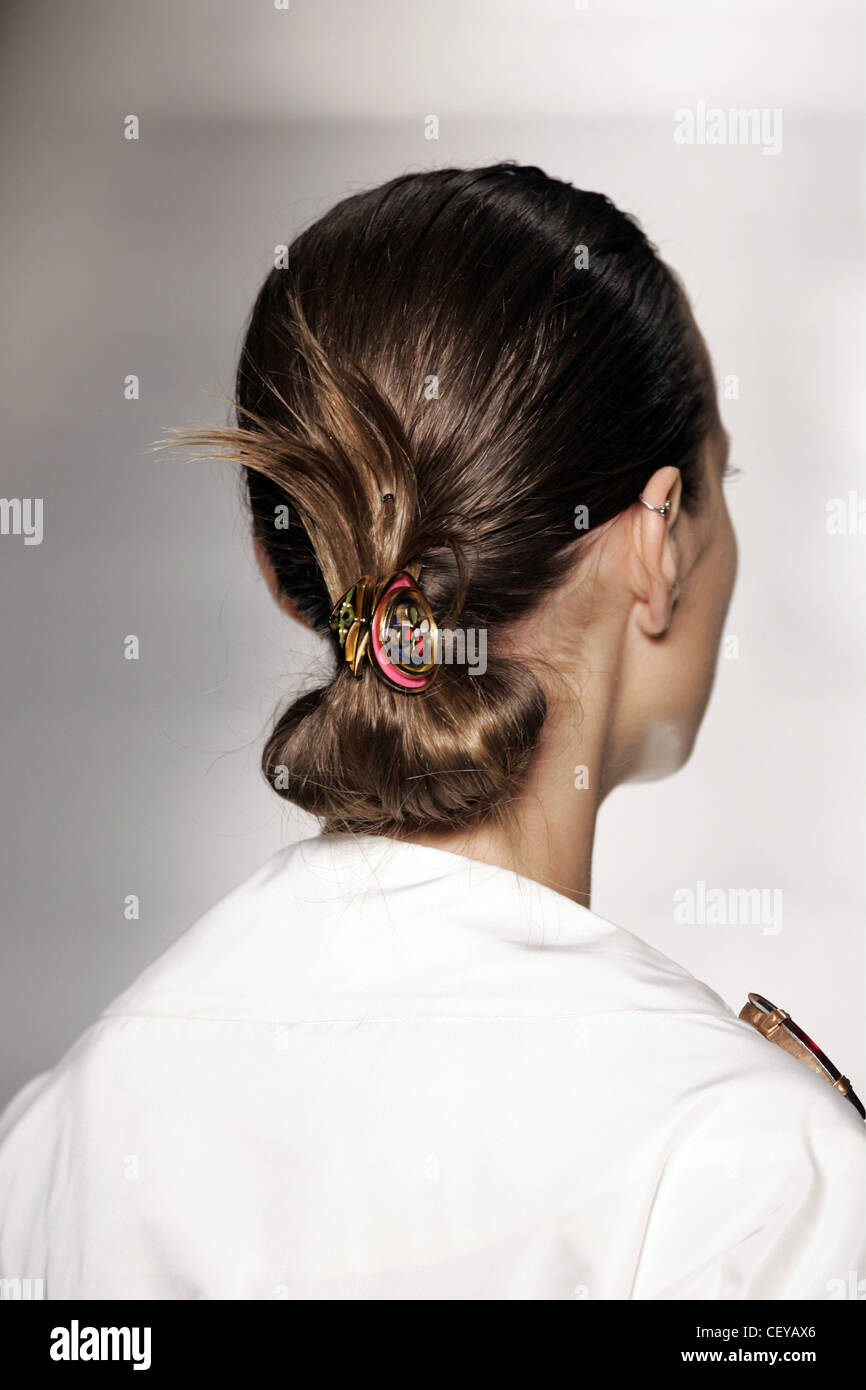 Vista posteriore del modello femminile la testa marrone capelli con bassa  chignon tenuto con piccolo rosso, giallo e verde fiore clip Foto stock -  Alamy