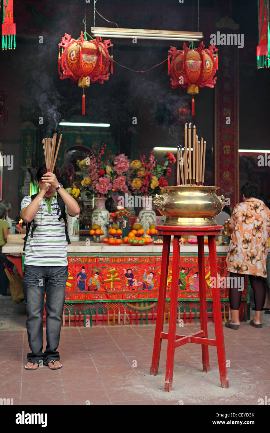 L'uomo depredavano con incenso a Guandi Tempio Taoista in Chinatown. Kuala Lumpur, Wilayah Persekutuan, Malaysia, sud-est asiatico Foto Stock