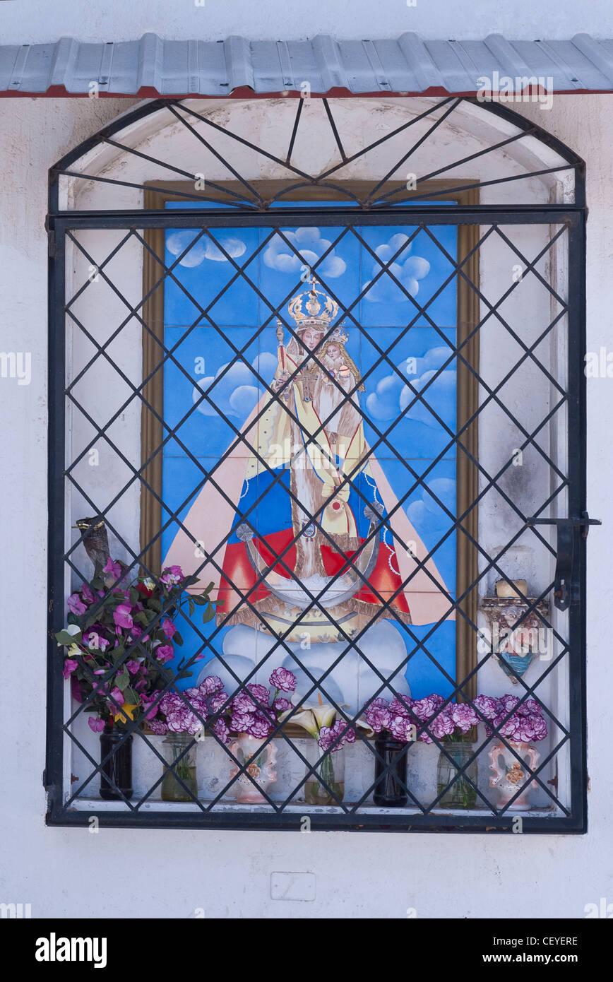 Un colorato dipinto piastrelle santuario della Vergine Maria dietro decorativi in ferro battuto in Luz de America, Ecuador. Foto Stock
