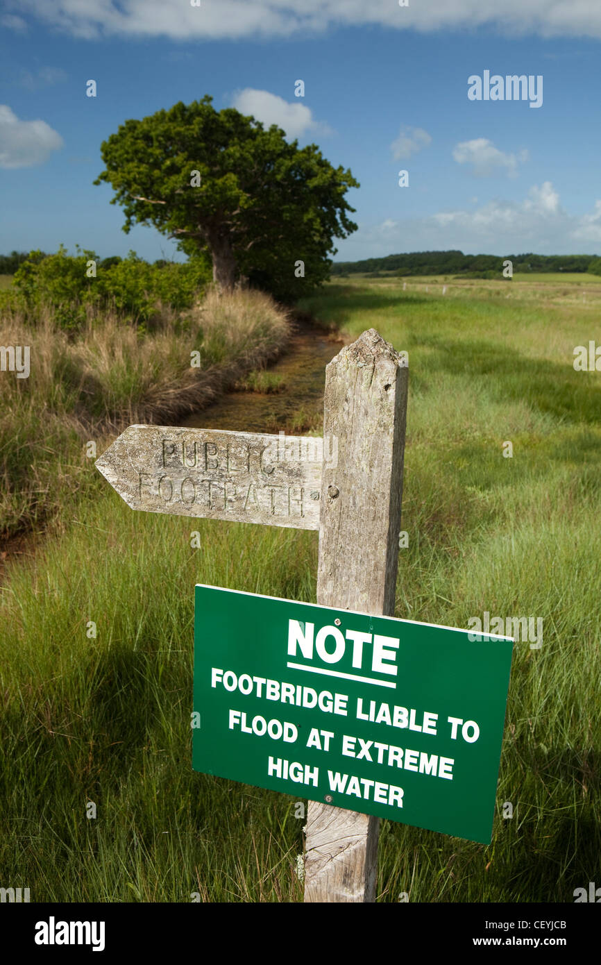 Il Regno Unito, l'Inghilterra, l'Isola di Wight, Newtown Saltmarsh, inondazioni segno di avvertimento a fianco di legno sentiero causeway segno Foto Stock