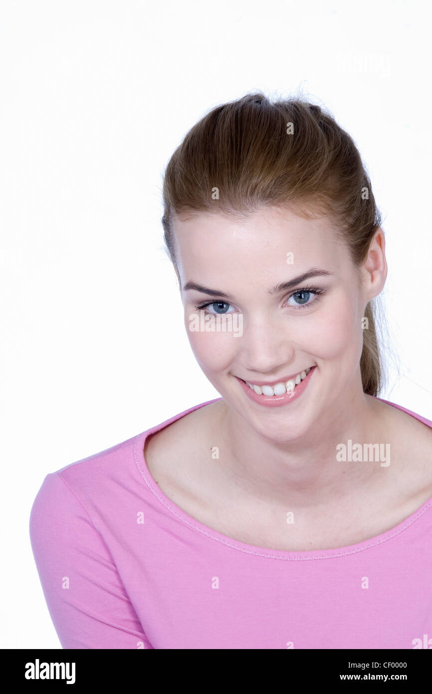 Femmina con capelli castani fuori la sua faccia, indossando un top lilla, sorridente, guardando la fotocamera Foto Stock