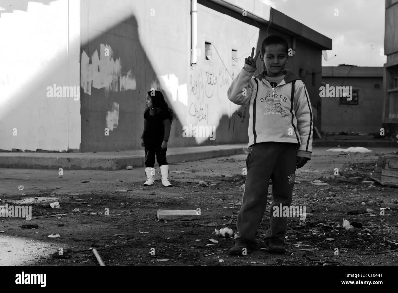 Giovane ragazzo libico mostra segno di vittoria a ex Gheddafi composto di Bab al-Azizia a Tripoli, Libia Foto Stock