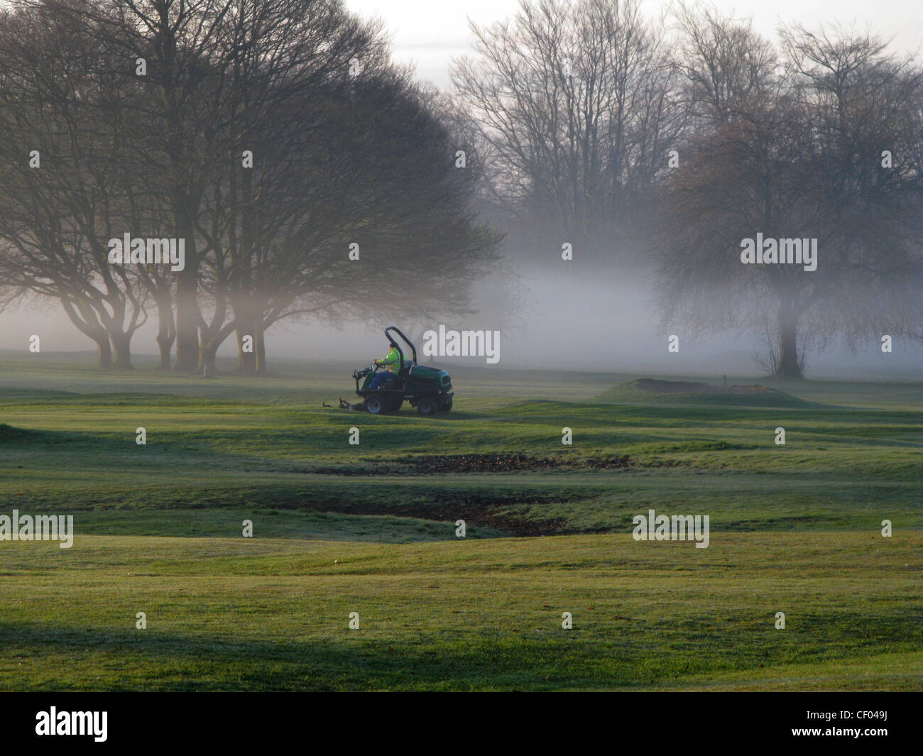 Un lavoratore groundsman tende il campo da golf pitch e mettere in War Memorial Park, Coventry, nella nebbia di mattina Foto Stock