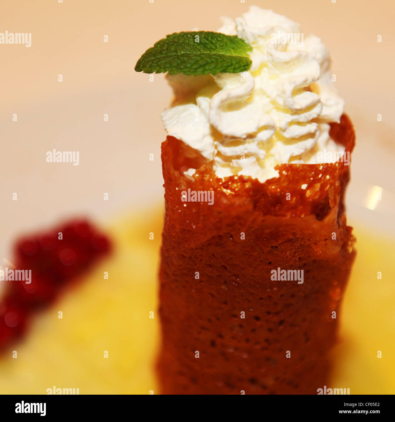 Una crema riempito di brandy snap condito con una foglia di menta. Foto Stock