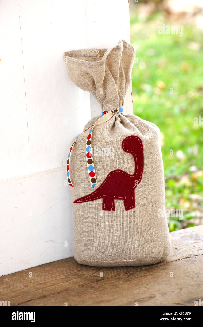 Per fare un piccolo pezzo di tessuto di lino viene tagliata e un dinosauro è cucita in feltro (questo può essere fatto mediante il tracciamento da un preferito Foto Stock