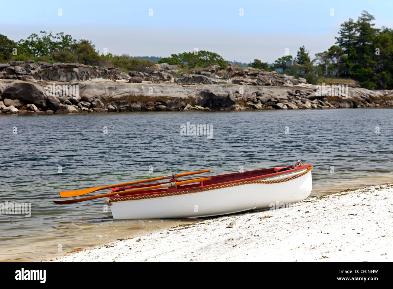 Roccioso riva del mare con una barca Foto Stock