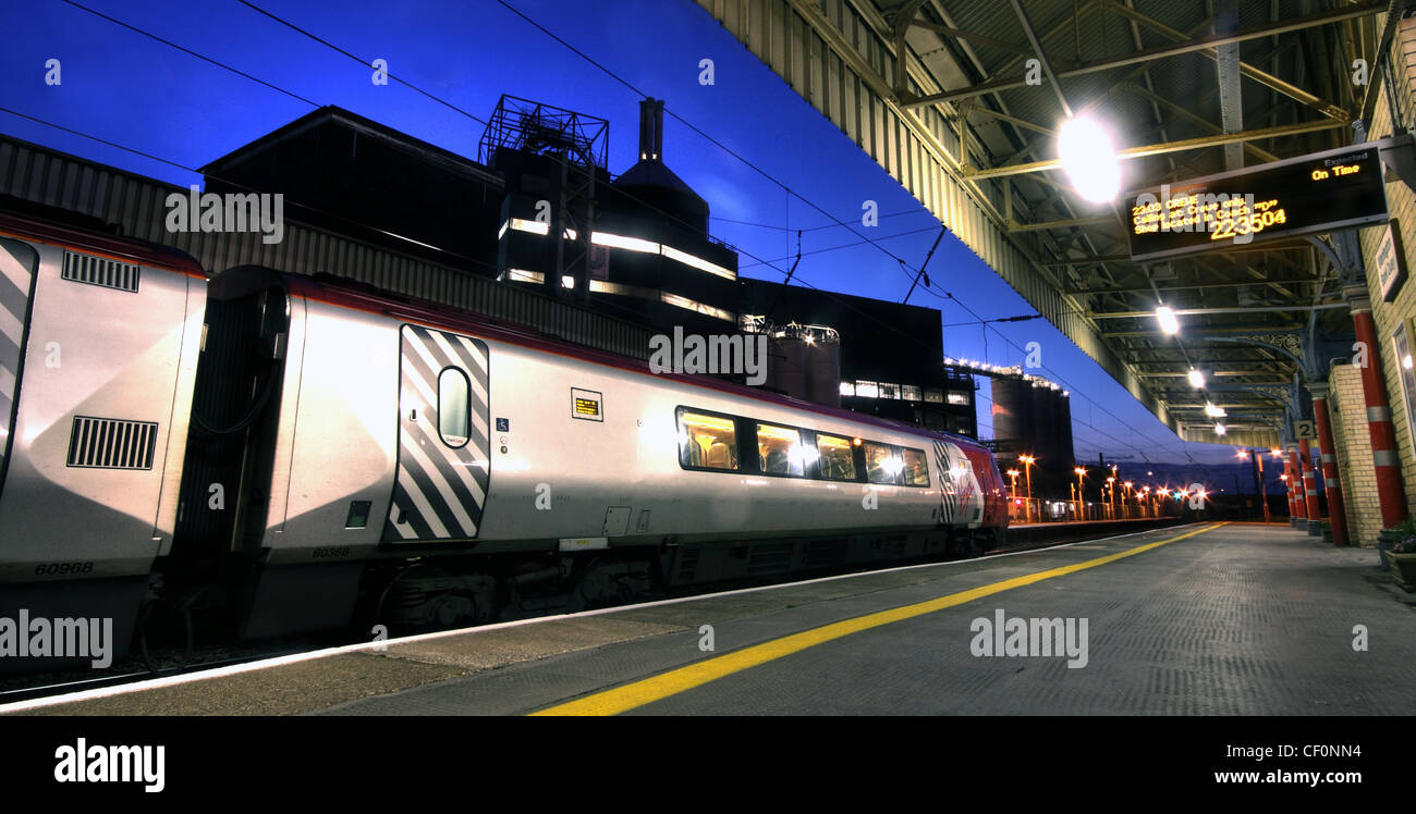 Piattaforma 2, Banca banchina principale stazione ferroviaria, Warrington, Cheshire Regno Unito al tramonto mostra vergine voyager treno Foto Stock