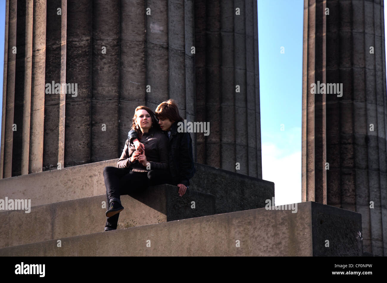 Giovani amanti a Calton Hill, Edinburgh , Lothian , Scozia , NEL REGNO UNITO , seduta sul neo-classico stile Greco monumenti Foto Stock