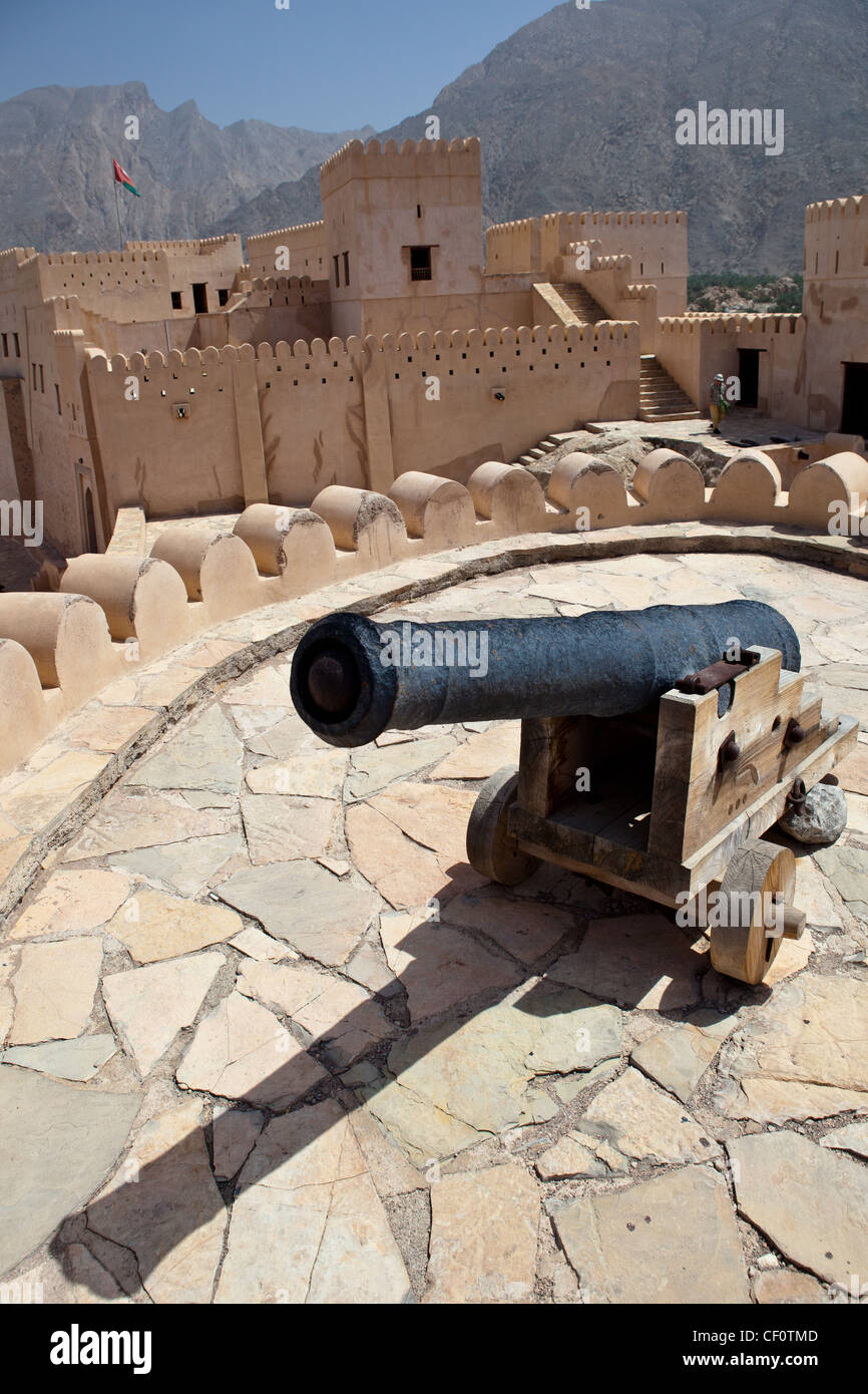 Vecchio canonico sulla sommità del Nakhl Fort, circondato da montagne Hajar (Al Batinah, Oman) Foto Stock