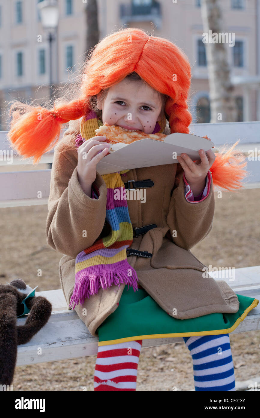 Bambina vestito come Pippi calza lunghe di mangiare la pizza Foto