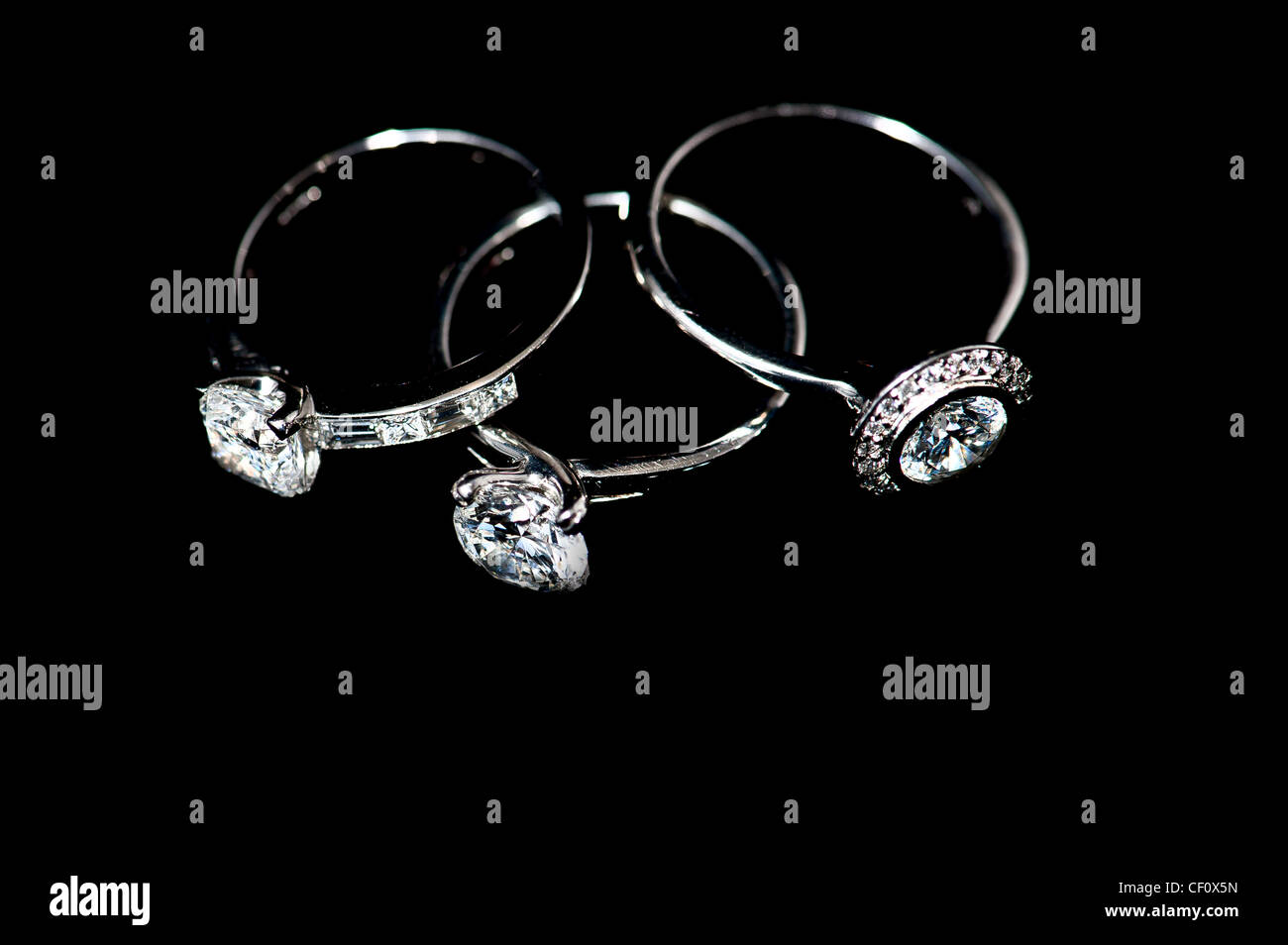 3 Diamond anelli di fidanzamento su nero Foto Stock