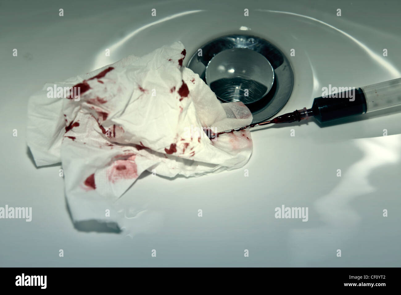Siringa con il sangue con un sangue-cosparse fazzoletto in un lavandino  Foto stock - Alamy