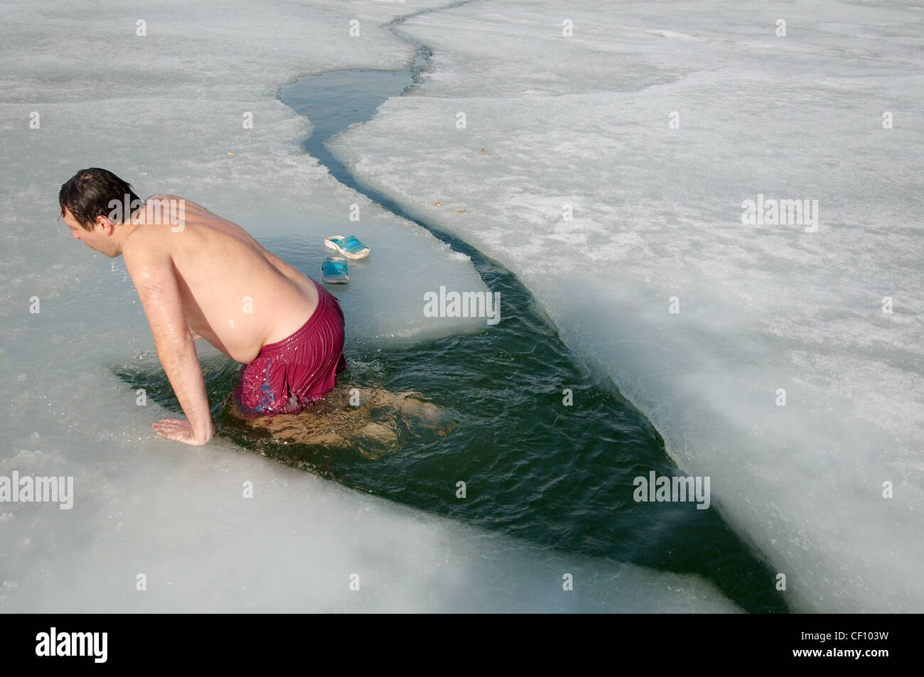 Uomo di nuoto nel foro di ghiaccio, Odessa, Ucraina, Europa orientale, Europa Foto Stock